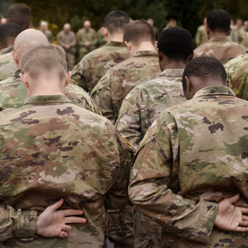 A group of soldiers in uniform praying